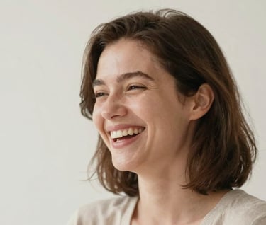 A warm, candid portrait of a woman laughing softly, her face partially turned toward a gentle light source. Minimalist background. Style is authentic and timeless. Palette uses #3F322A and #F8F5EF.