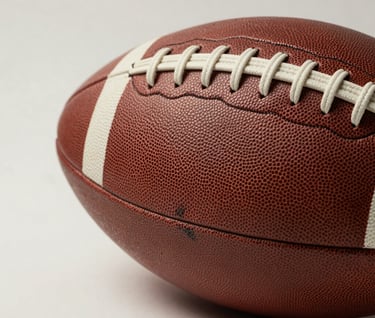 Extreme close-up photography of a worn leather football on a minimalist off-white background. The lighting is soft and directional, emphasizing every stitch and scuff, reflecting ten years of elite sport history.