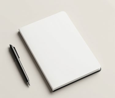 Top-down view of a minimalist workspace. A single black metallic object and a clean white sketchbook lie on a cream surface (#F8F5F2). Abundant negative space around the items, reflecting a sense of luxury and focus.