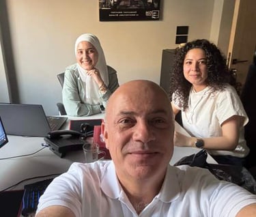 a man and woman sitting at a desk with laptops