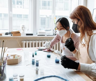 dos mujeres mesclando resina con colorante Azul en Uno's vasos