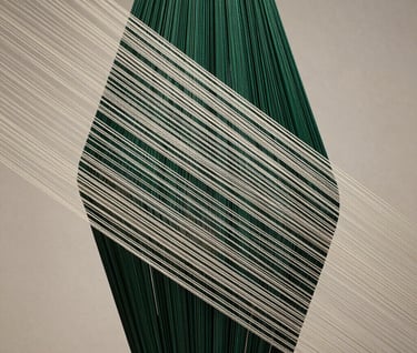 A vertical photograph of a sculpture piece where thin silk threads are tensioned to create geometric patterns. The lighting is sophisticated, casting delicate linear shadows in deep forest green and off-white.