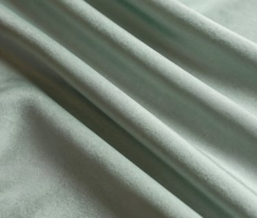 A detailed shot of layered fabric works. The overlapping silk creates new shades of muted sage green and pale silver-green, suggesting a deep, cosmic perspective within a confined space.