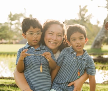 mother hugging her two children in warm sunset light at rimba by ayana bali during a candid bali family photography session