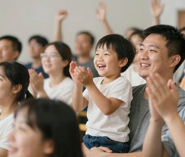 A candid shot of the crowd cheering. A young child is clapping with a wide smile, being held by an adult. The focus is on the human connection and the atmosphere of the event. Soft, approachable lighting, using #F2F1ED for a bright, positive feel.