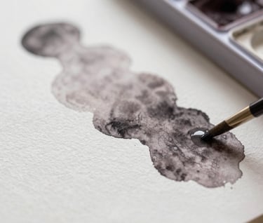 Close-up detail of watercolor pigments bleeding into textured white paper, capturing the professional craftsmanship of the liquid medium with touches of #6F5E52.