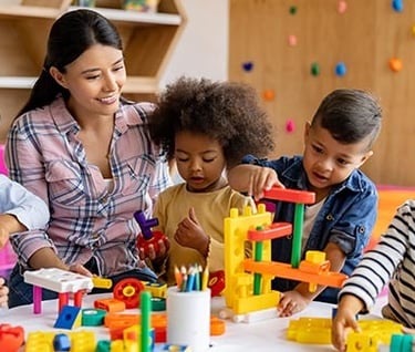 a woman and children playing with blocks and toys