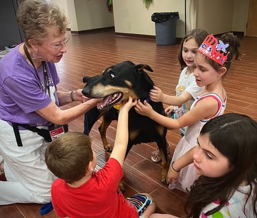 Tender Paws Therapy Animal Team Janet and Bentley interact with children.