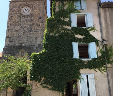 Tour d’horloge historique en pierre à côté d’une maison de village à Quillan, 