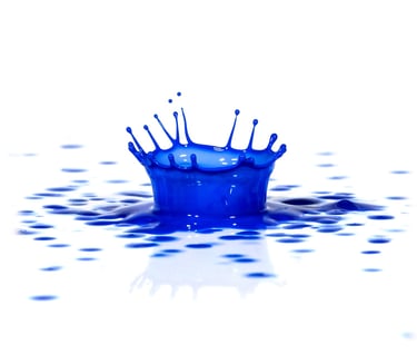 Blue paint splash macro image on a white surface