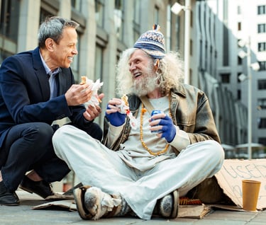 a man sitting on the ground with a sign that says,'i am sorry