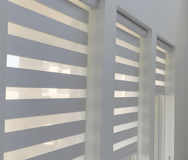 a bedroom with a bed and a window with blinds