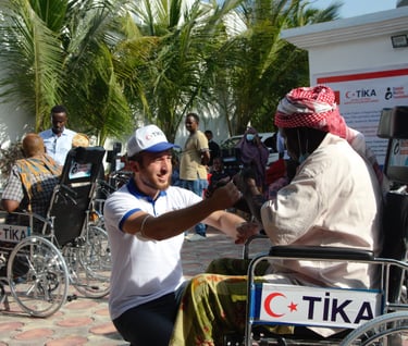 Somali men with disabilities supported by Turkish aid organization cooperating with Taraahamo, emphasizing solidarity and ass