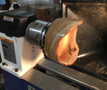 Spalted Cascara Natural Edge Bowl, mounted on lathe, illuminated interior