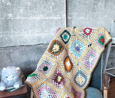 a person sitting in a chair with a blanket on it