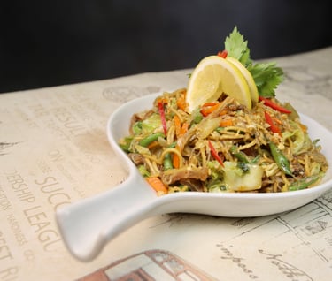 a bowl of "pancit guisado" with lemon toppings