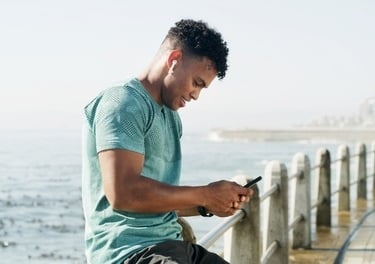 a man sitting on a bench looking at his cell phone