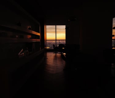 Dark interior with a sunset‑lit window in Phnom Penh, By ACAT Photos