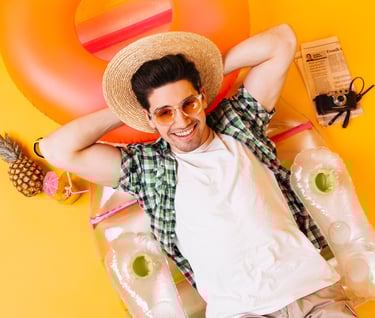 a man in a hat and sunglasses laying on a float ring