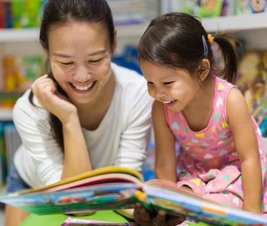 mom and toddler read a book together