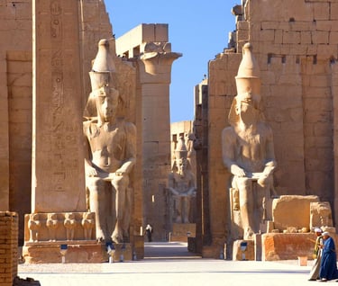 a woman in a blue dress standing in front of a large statue