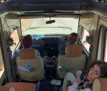 a woman sitting in a vehicle with two men