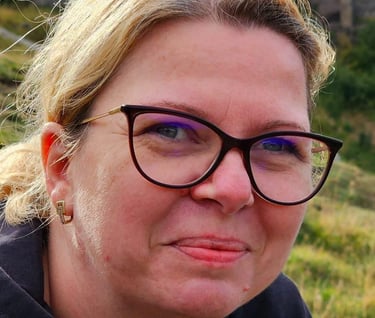 a woman with glasses and a black jacket