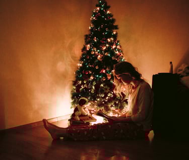 A woman sitting by the Christmas tree
