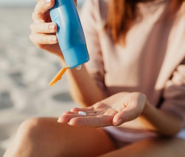 Woman applying sunblock by the beach