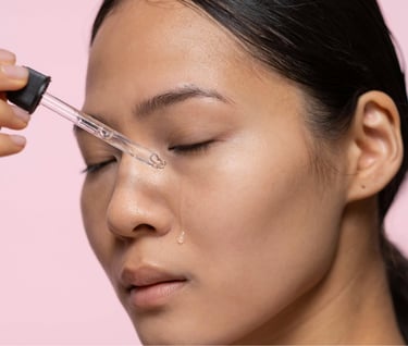 Asian woman applying serum on her face