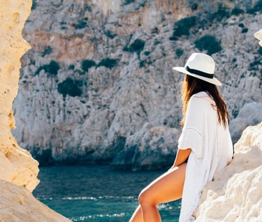 A woman wearing a white shirt and white cap on vacation