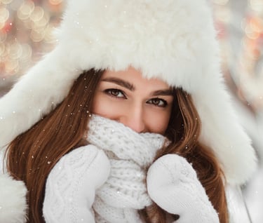 Woman in winter coat and hat out in the snow.