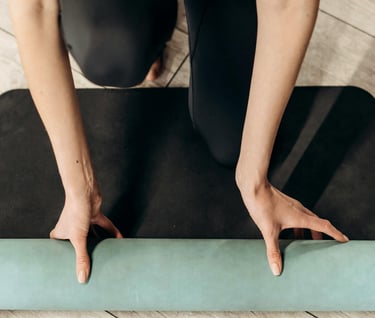 Woman in black leggings with a workout mat for pilates