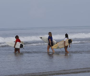 Group of surfer girls entering the water