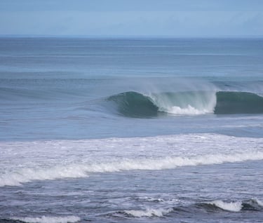 A perfect unridden pick wave with a surfer behind ready to catch another great wave