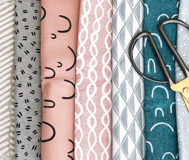 a bunch of fabrics and scissors on a table