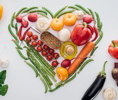 heart made of green peas and fresh ripe vegetables with spices isolated on white