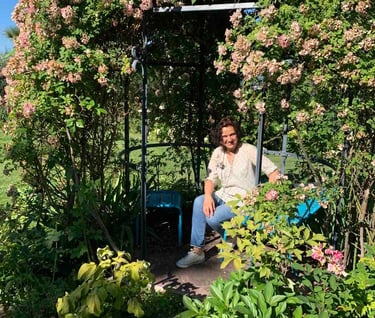 a woman sitting on a bench in a garden