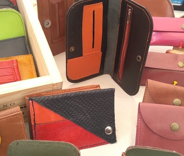 Un montón de carteras y monederos de diferentes colores.