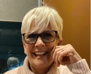 a woman with glasses and a sweater on