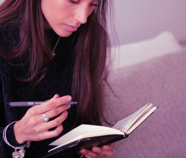 journaling lady in black knitted clothes with purple pen