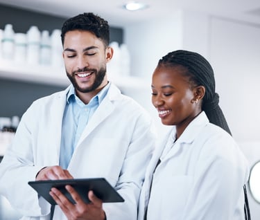 A male pharmacist and female pharmacist looking at a tablet