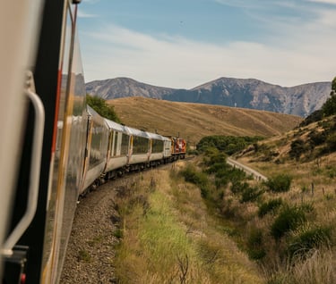 a train traveling down a mountain side by side