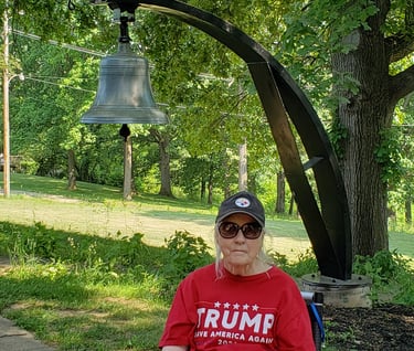 Lady in front of school bell