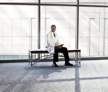 a man in a white lab coat sitting on a bench