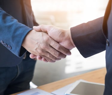 two people shaking hands with a laptop