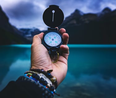 Main tenant une boussole devant un lac : une cible Data & AI se définit avec des outils