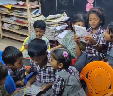 a group of children sitting around a table and studying