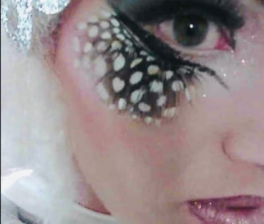 geschminktes Frauengesicht mit Ferderwimpern,Glitzerlippen und Rouge