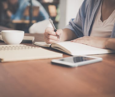 Writing by hand in a journal.